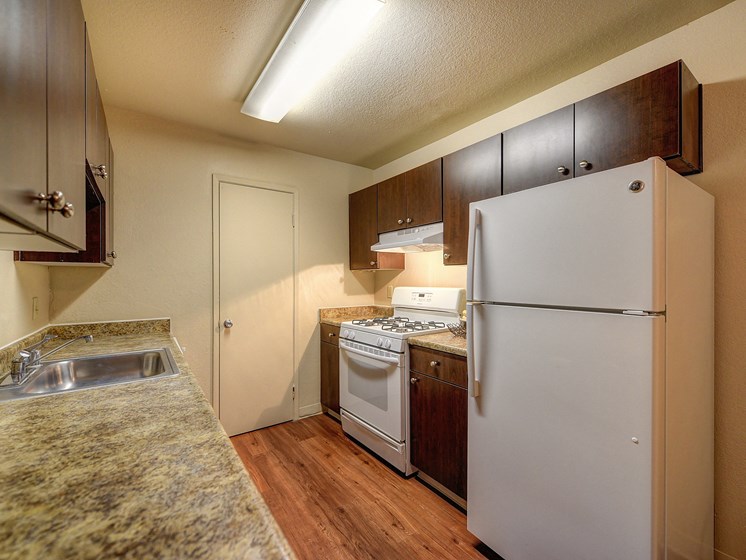 Kitchen with Granite Quartz Countertops, Hardwood Inspired Floors, Wood Cabinets, Refrigerator/Freezer, Oven, Stove
